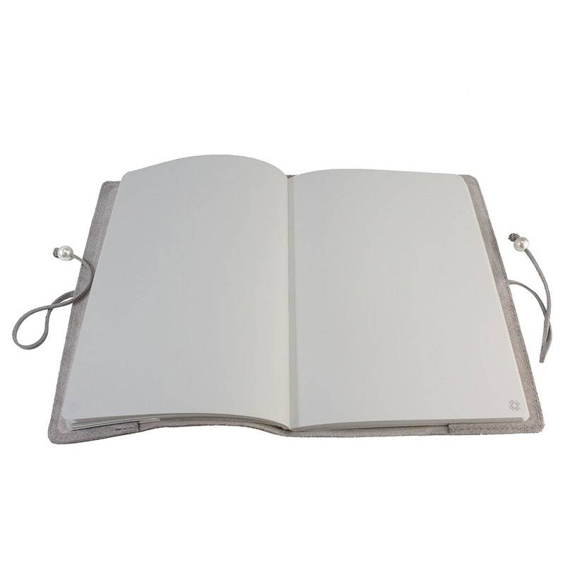 Libreta de Piel Niza abierta con páginas lisas y acabado en piel brillante.
