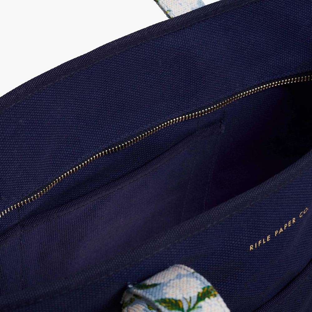 Bolso de Lona Hydrangea de Rifle Paper Co. con diseño floral, bolsillo interior y asas reforzadas.