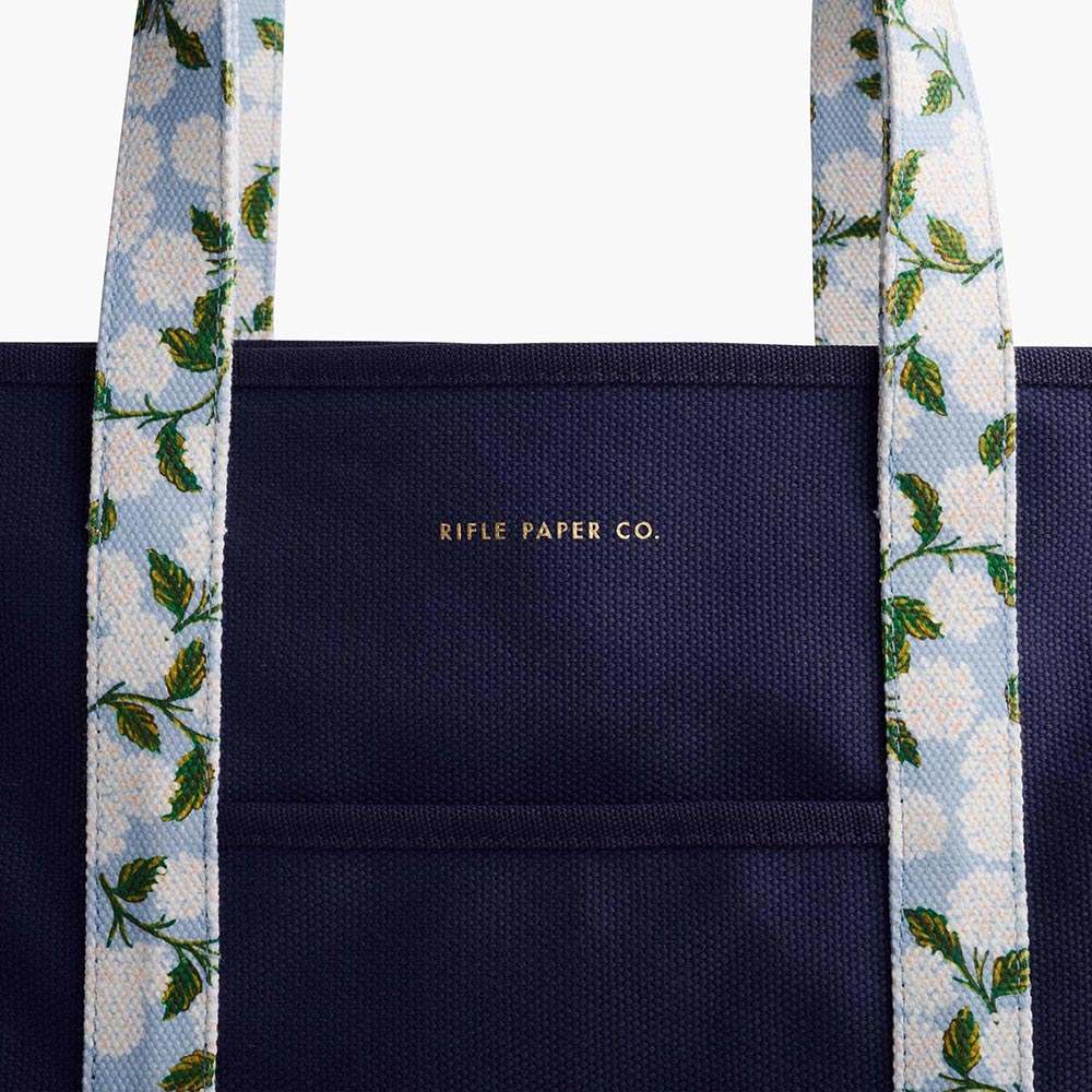 Bolso de Lona Hydrangea de Rifle Paper Co. con elegante diseño floral y asas reforzadas.