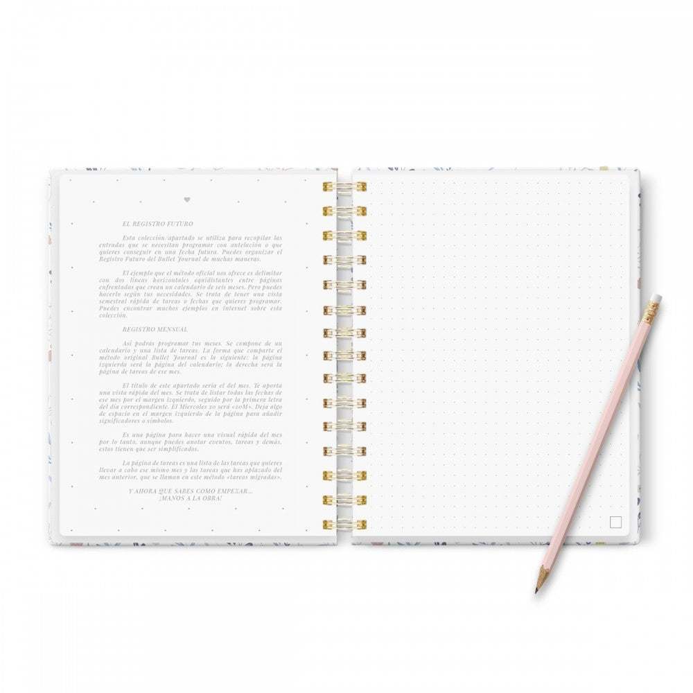 Cuaderno Bullet Journal Mediterranea abierto con páginas punteadas y diseño floral, tamaño A5, junto a un lápiz.