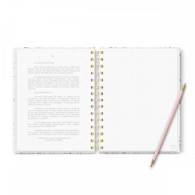 Cuaderno Bullet Journal Mediterranea abierto con páginas punteadas y diseño floral, tamaño A5, junto a un lápiz.