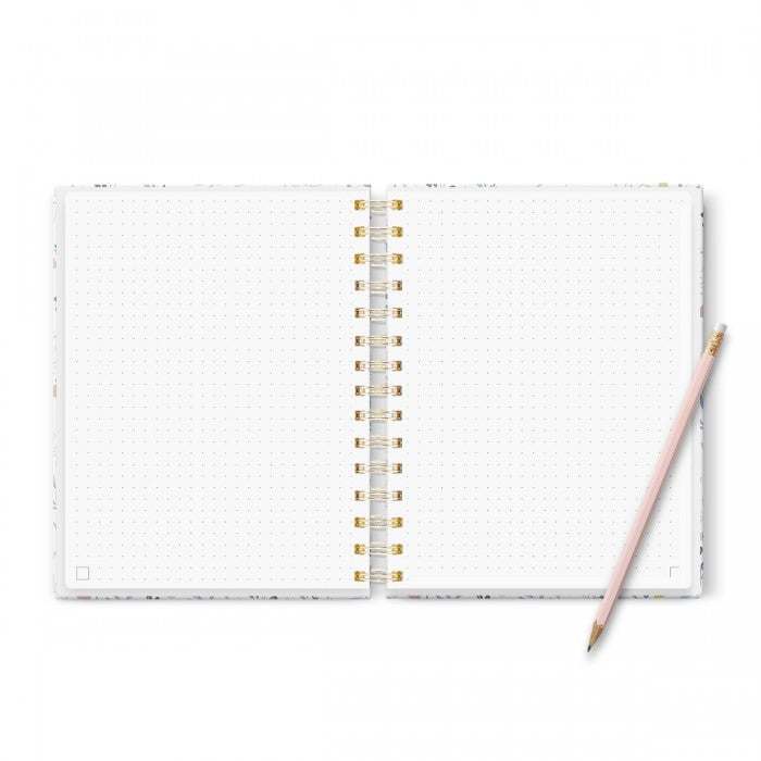 Cuaderno Bullet Journal Tengo un Plan, tamaño A5, abierto con páginas punteadas, anillas doradas, y lápiz cerca.