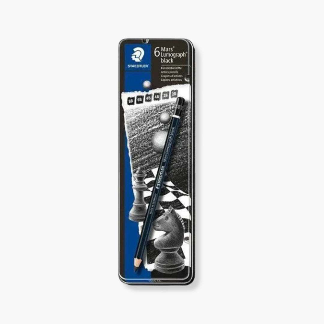 Lápices Artísticos Mars Lumograph Black en caja metálica, ideales para dibujo y sombreado.