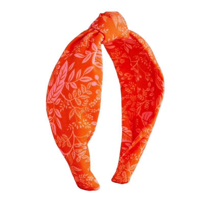 Diadema de tela estampada en naranja con detalle de nudo, ilustración Rifle Paper Co.