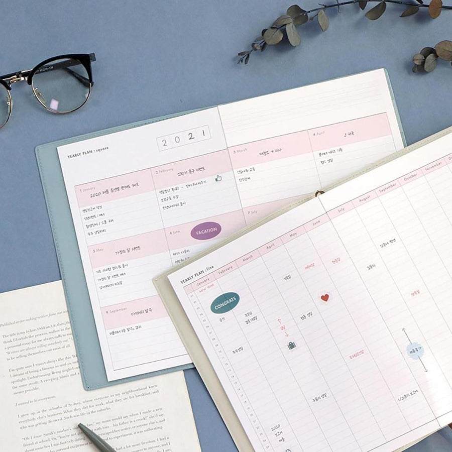Office Planner ICONIC Ivory open on a desk with glasses and a pen nearby.