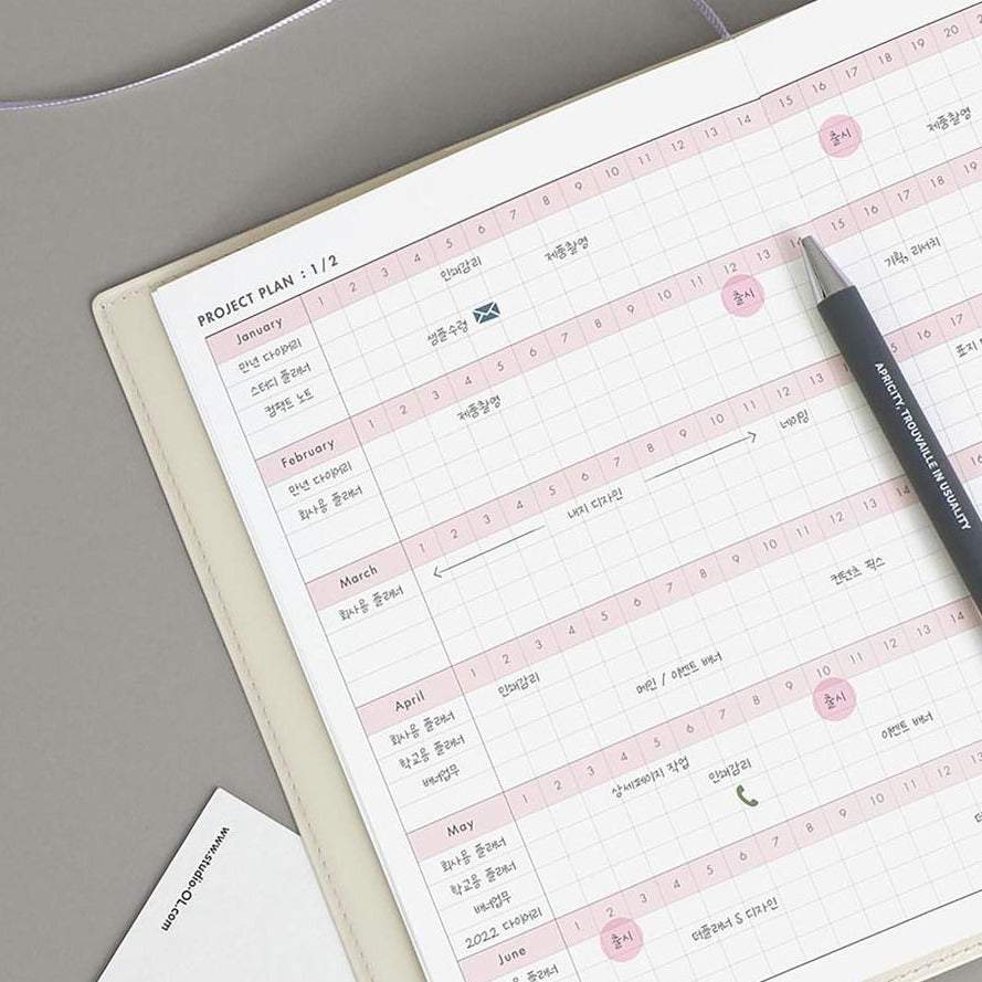 Office Planner ICONIC Ivory with project plan pages and pen on top.