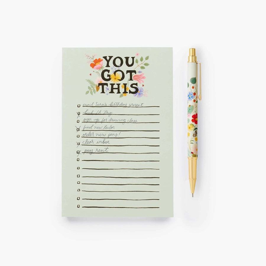 Portaminas Strawberry Fields con diseño floral y detalles dorados junto a cuaderno "You Got This".