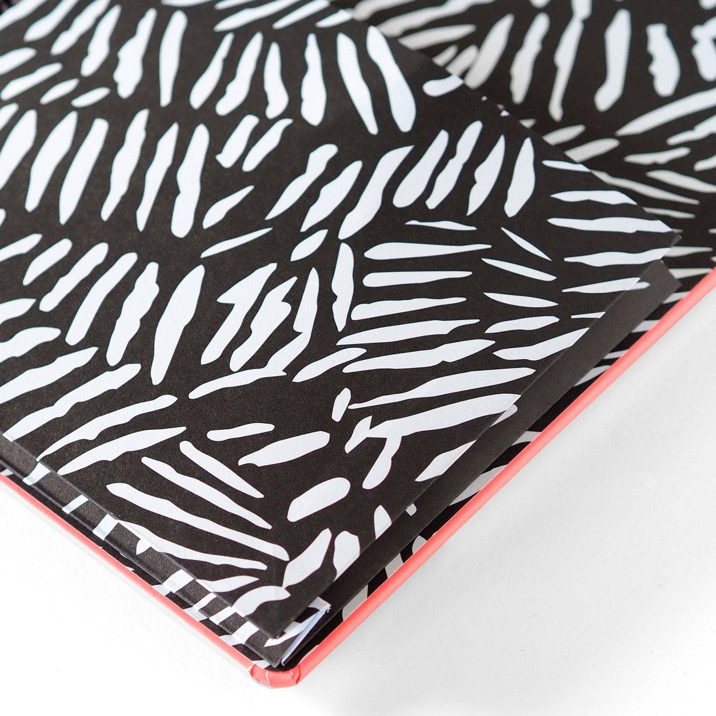 Libreta Shout Out Loud con diseño llamativo, tapa dura coral, bordes redondeados, papel rayado de alta calidad y bolsillo interior.