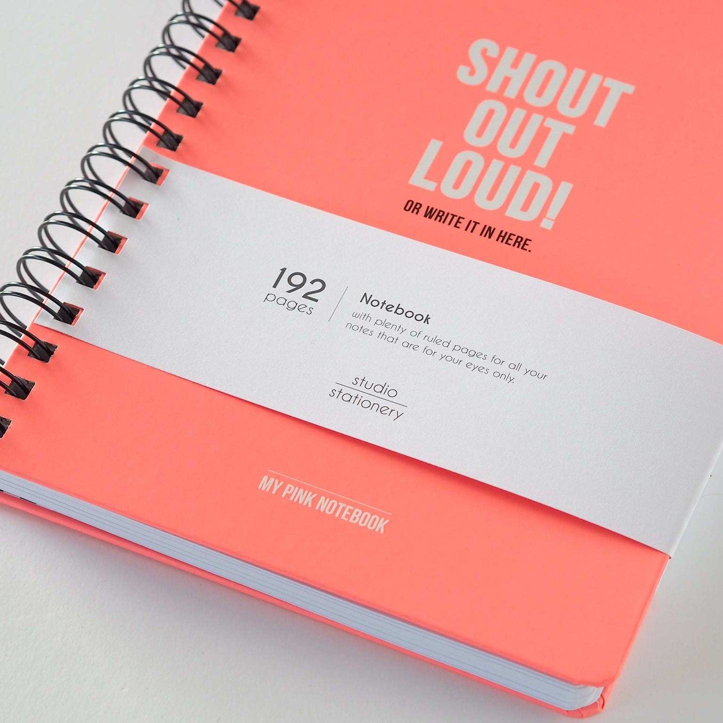 Libreta Shout Out Loud en color coral con espiral y frase inspiradora, perfecta para expresar creatividad y organizar notas.