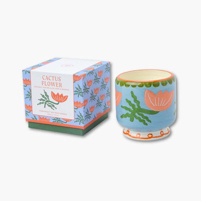 vela perfumada en recipiente de cerámica pintada junto con su caja de cartón de paddywax con dibujo de flores