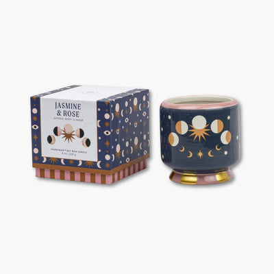 vela perfumada en recipiente de cerámica pintada junto con su caja de cartón de paddywax con dibujo de fases lunares