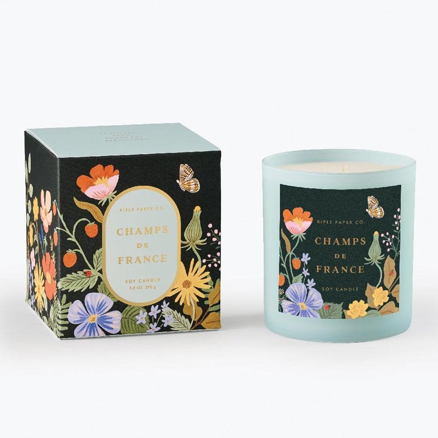 Vela Perfumada Champs de France de Rifle Paper Co., elegante presentación con vidrio pintado y caja decorativa, fragancia de lavanda, salvia, romero y bergamota.