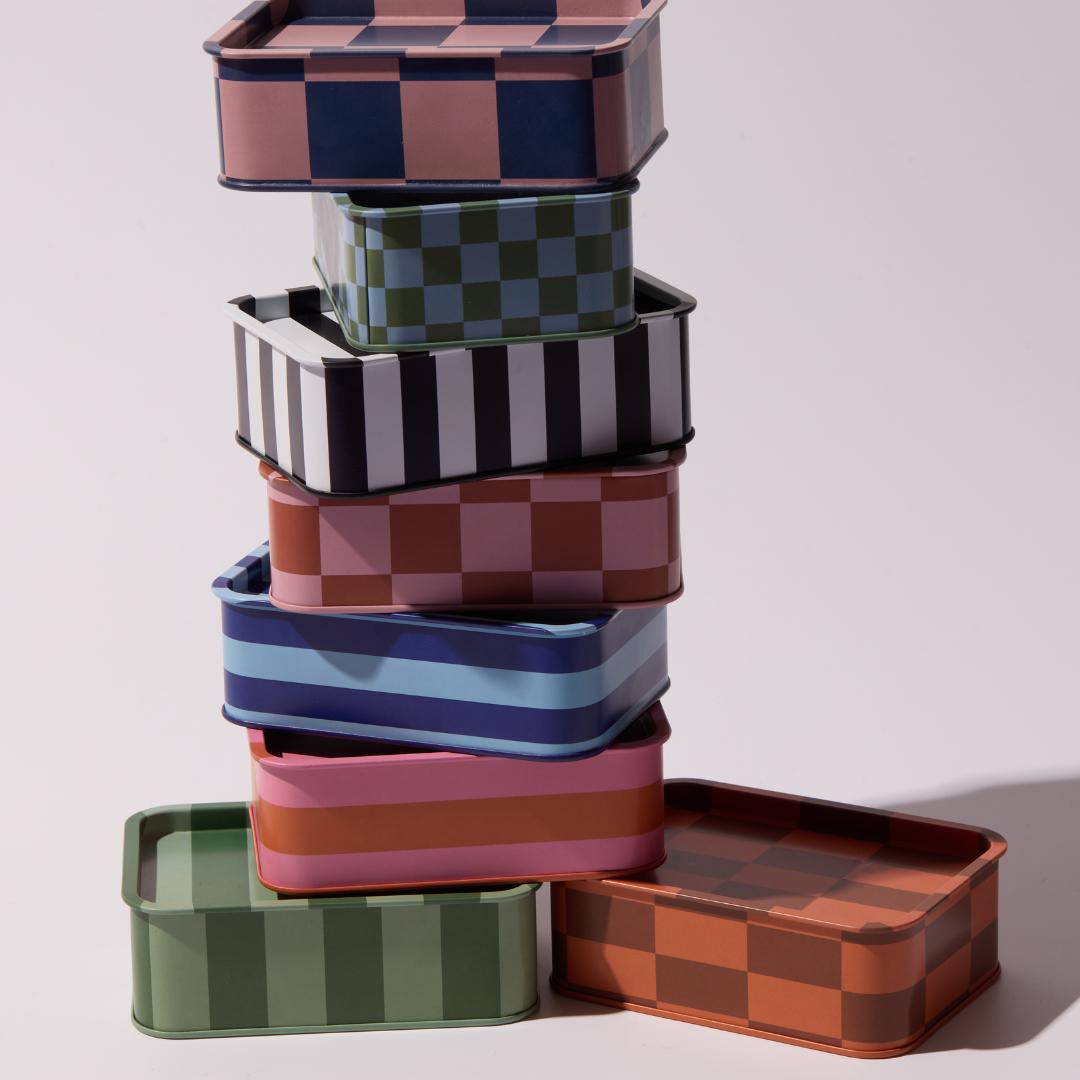 columna de velas en lata de diferentes diseños y colores