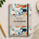 Cuaderno A5 Alljoy Design Curious Cats con gatos de colores sobre fondo azul claro
