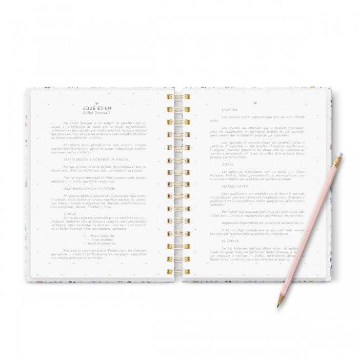 Cuaderno Bullet Journal "Tengo un Plan" abierto con lápiz, tamaño A5, páginas punteadas, anillas doradas.
