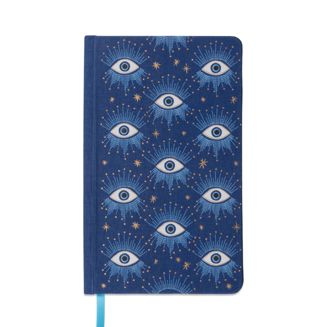 portada de cuaderno con tapa entelada en color azul con diseño de ojos sobre cielo estrellado