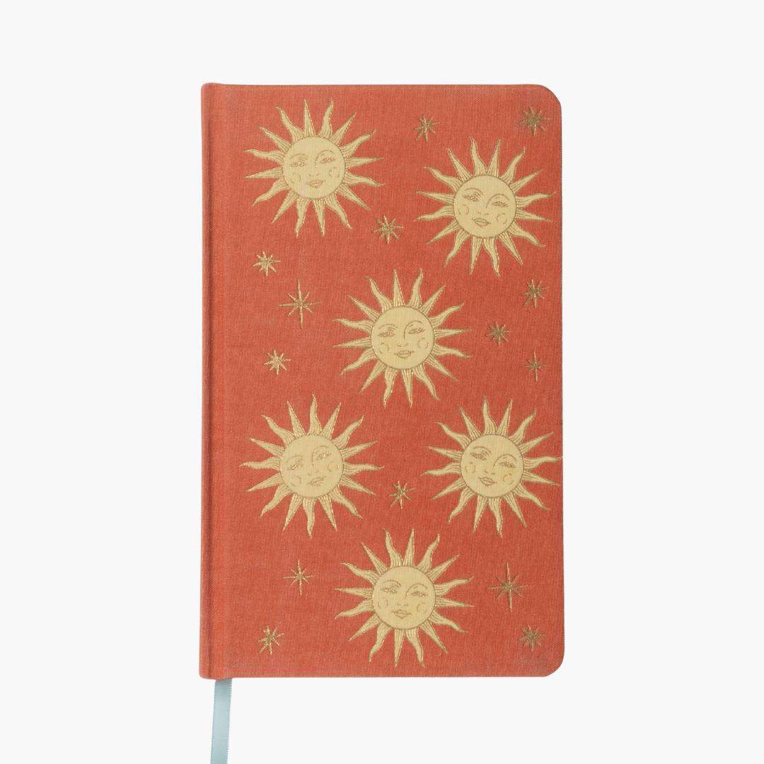 portada de cuaderno con tapa entelada en color terracota con diseño de soles