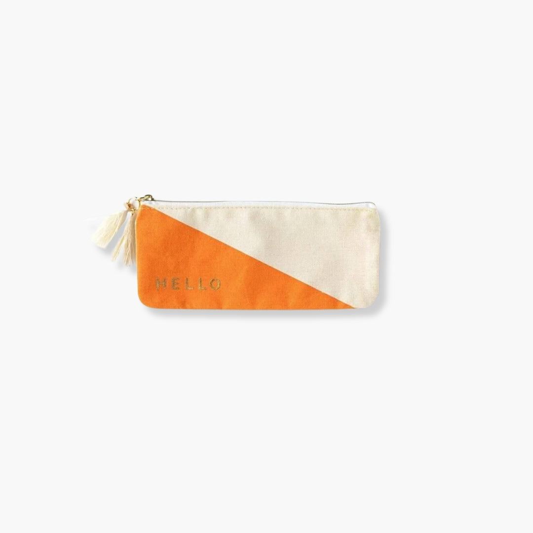 Estuche de Tela Hello, diseño bicolor naranja y beige, con texto dorado y borlón decorativo.