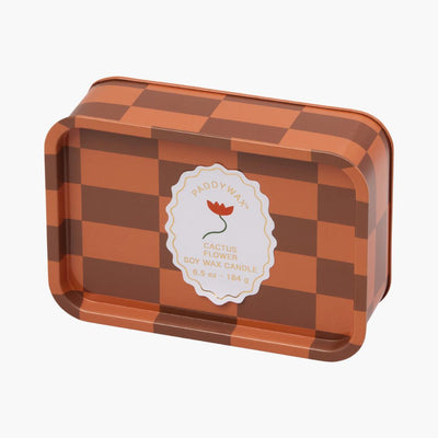 lata con vela con diseño de cuadros en colores naranjas