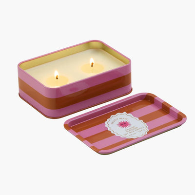 lata con vela con diseño de rayas en colores rosas y naranjas